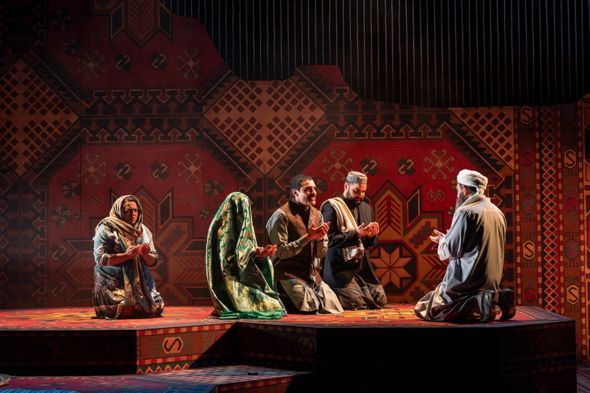 Rasheed and Laila are being married in a traditional ceremony. Her face is covered by a veil. Mariam sits behind, with a distressed expression on her face. All of the characters have their hands raised in prayer.