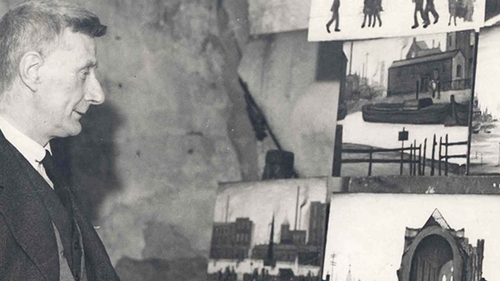 Фотография художника Л. С. Лоури, стоящего перед своими картинами